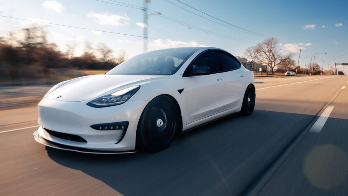 Turo Side Hustle: Is It Worth It in 2026? white tesla driving on the road
